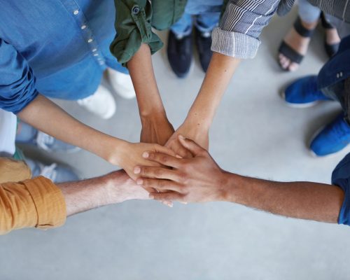 Solidarity and unity conept. Cropped shot of business partners holding their hands together expressing their agreement. True friends keeping their hands together swearing always help each other